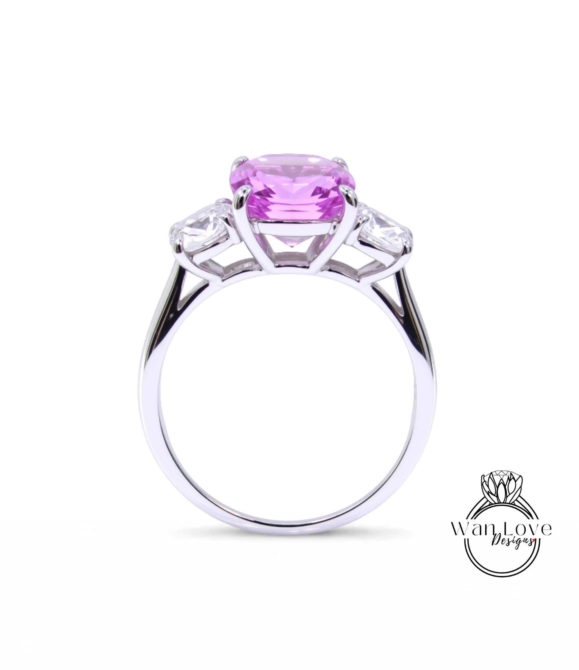 A silver ring with a large pink gemstone, possibly a sapphire, set in a three-prong design.