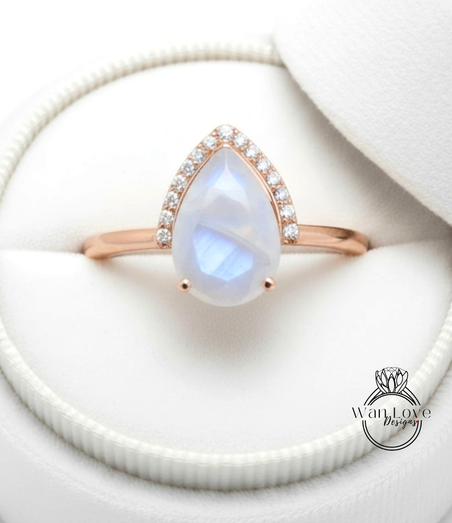 A close-up view of a rose gold ring with a large, clear moonstone set in the center, surrounded by smaller diamonds.