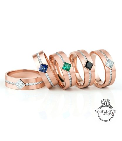 a collection of five gold-colored rings with gemstones, arranged in a row on a white background.