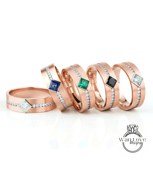 a collection of five gold-colored rings with gemstones, arranged in a row on a white background.