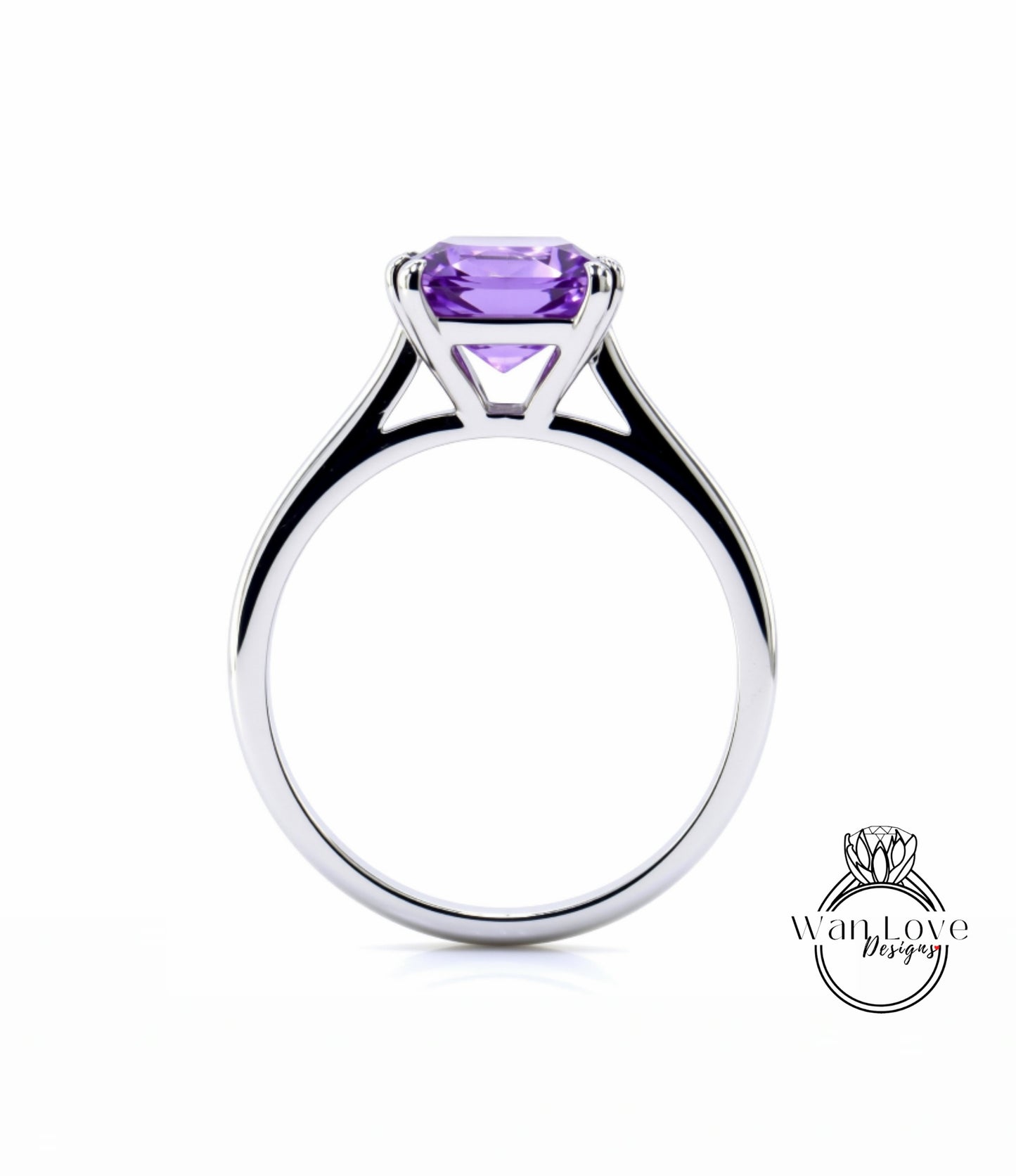 A silver engagement ring with a large, clear purple gemstone set in the center.
