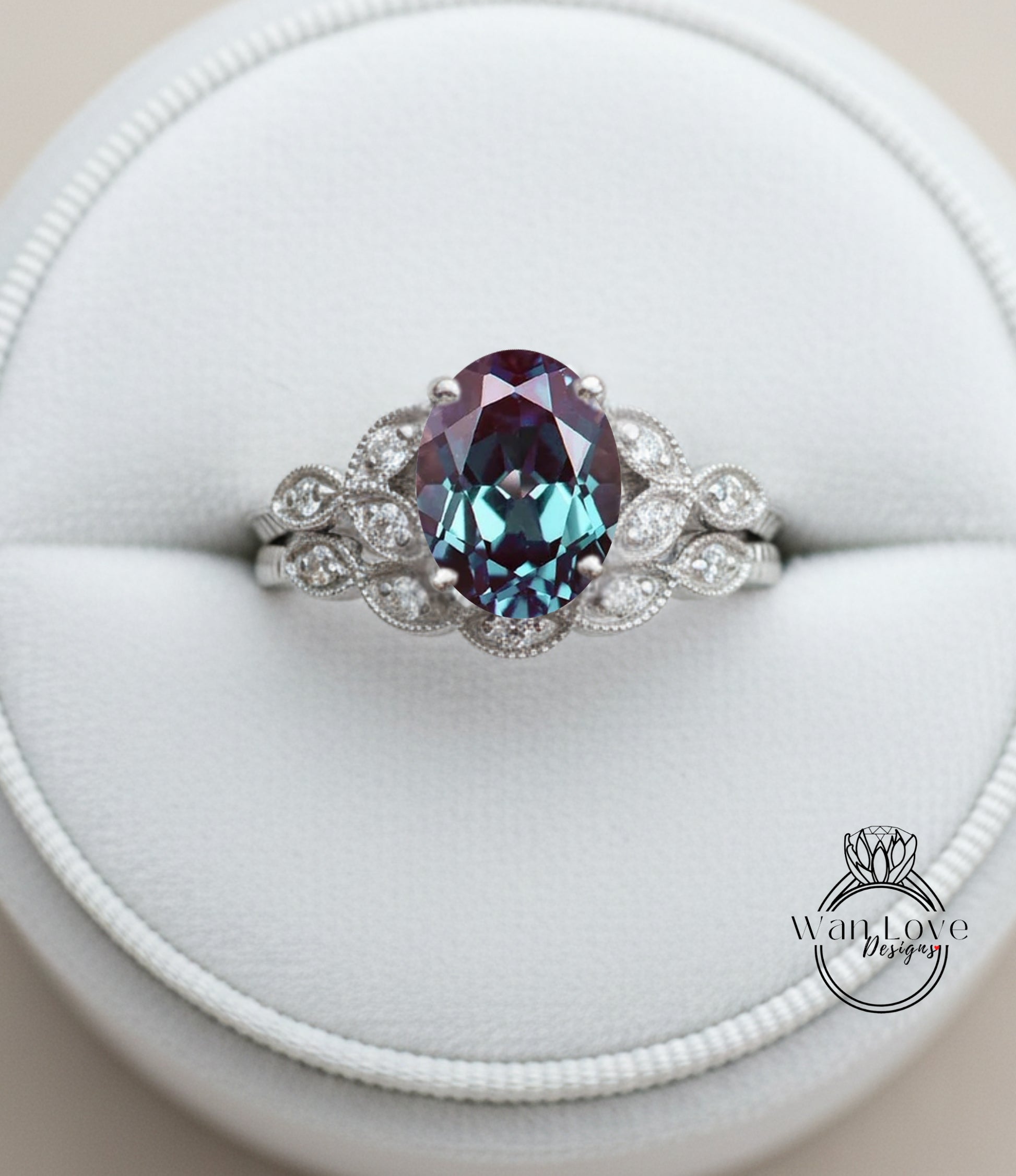 A close-up image of a silver ring with a large oval-shaped gemstone, possibly a sapphire, surrounded by smaller diamonds.