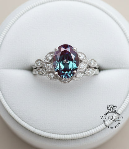 A close-up image of a silver ring with a large oval-shaped gemstone, possibly a sapphire, surrounded by smaller diamonds.