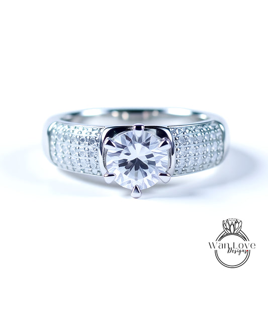 A close-up view of a diamond engagement ring with a large central diamond surrounded by smaller diamonds set in a silver band.