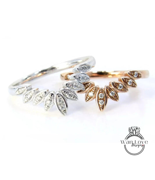 two rings with diamond-encrusted designs, one silver and one gold, placed on a white background.