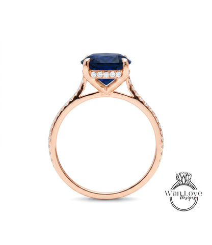 A rose gold engagement ring with a large blue gemstone and small diamonds set in the band.