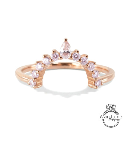 A rose gold ring with a unique design featuring a central diamond surrounded by smaller diamonds arranged in a fan-like pattern.
