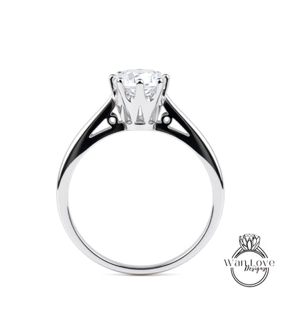 A silver engagement ring with a large central diamond and a smaller diamond on either side.