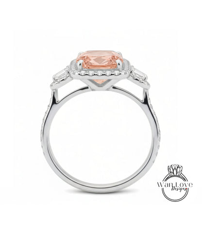 A silver ring with a large, peach-colored gemstone set in the center, surrounded by smaller diamonds.