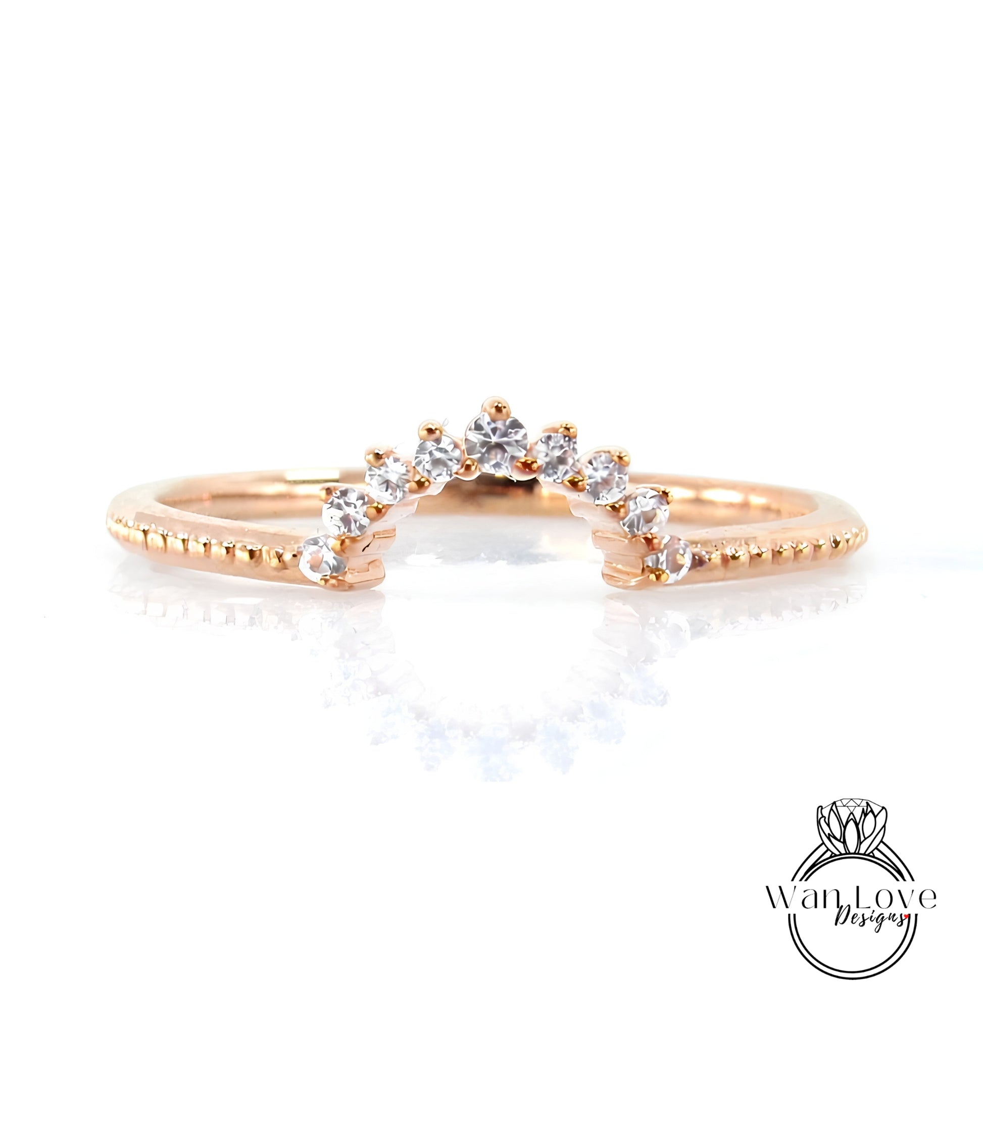 A rose gold ring with a diamond-encrusted band and a central diamond-encrusted band, featuring a small diamond in the center.