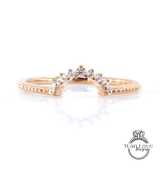 A rose gold ring with a diamond-encrusted band and a central diamond-encrusted band, featuring a small diamond in the center.