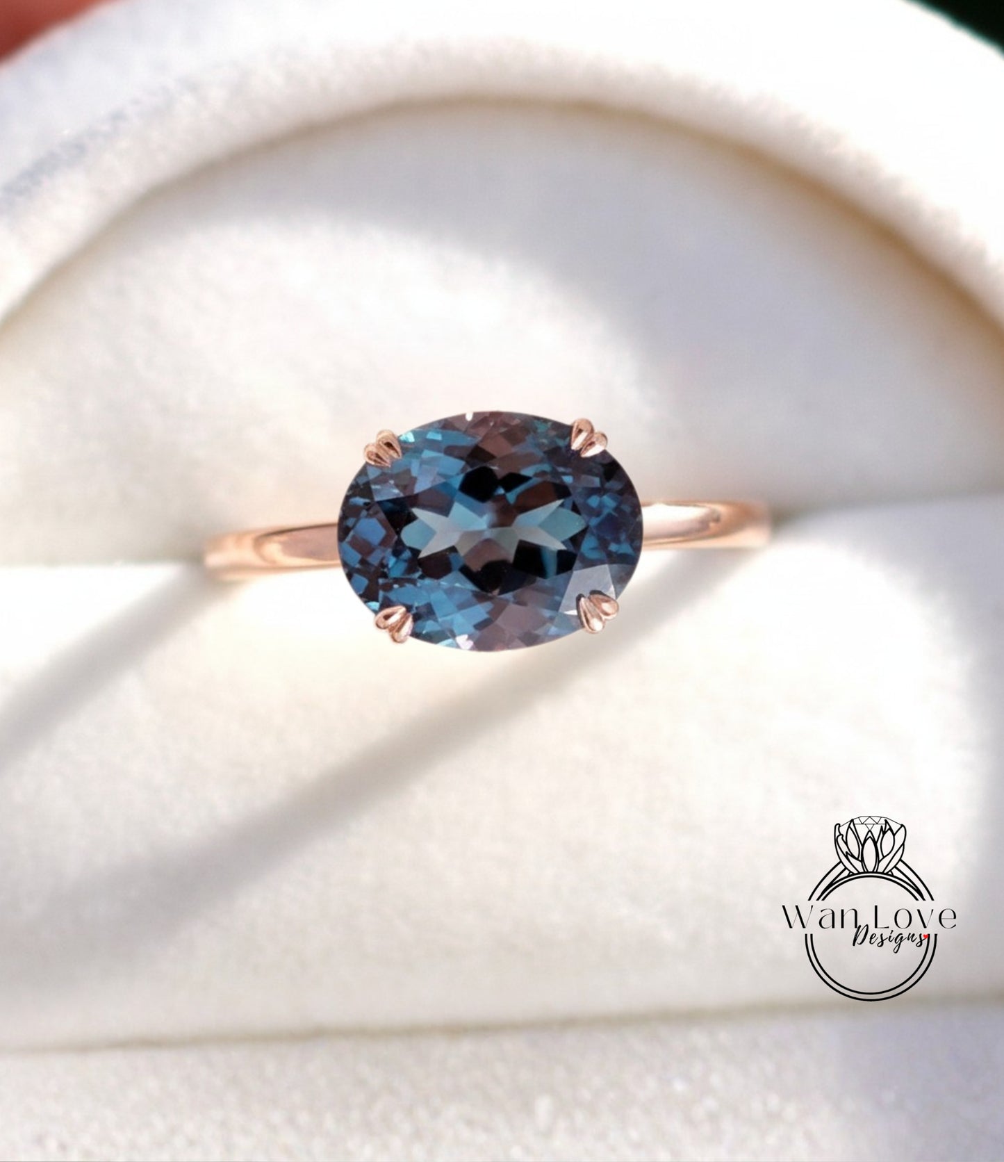 A close-up image of a gold ring with a large blue gemstone, placed on a white background.