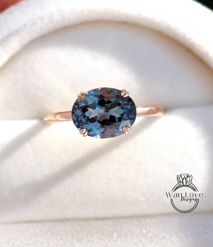 A close-up image of a gold ring with a large blue gemstone, placed on a white background.