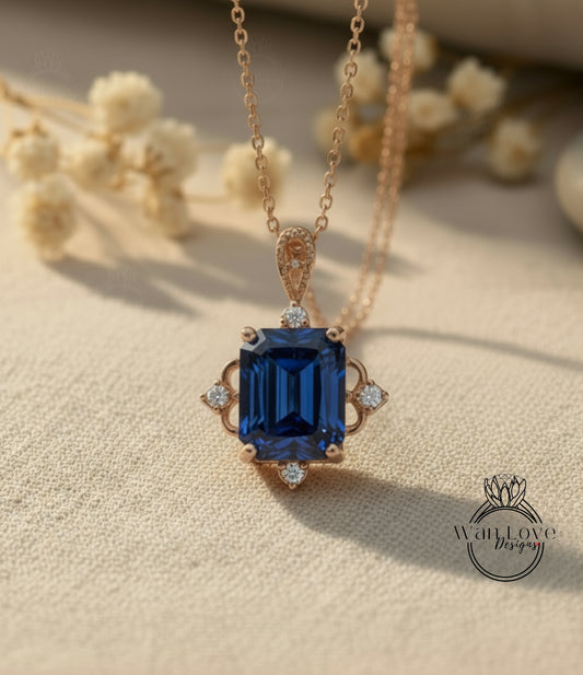 A close-up of a gold necklace with a large blue gemstone pendant, resting on a beige fabric background.