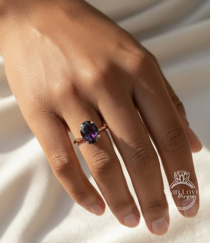A close-up of a hand wearing a ring with a large purple gemstone.