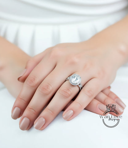 A close-up of a person's hand wearing a large diamond engagement ring.