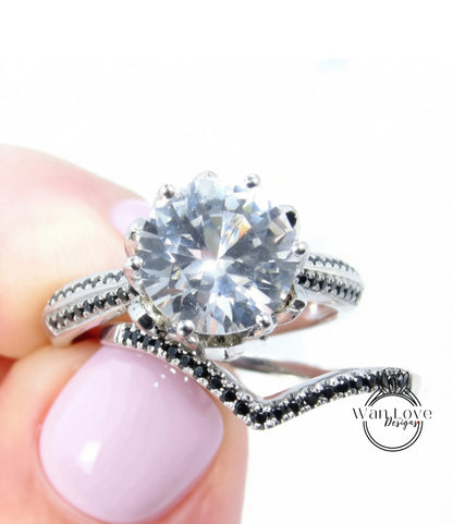 A close-up image of a person's hand holding a silver ring with a large, clear gemstone set in it.