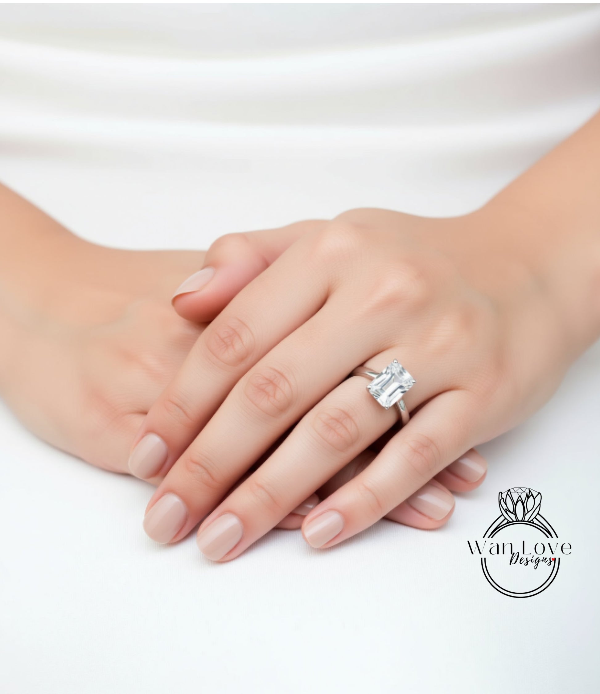A close-up of a person's hands with a large diamond engagement ring on the ring finger.