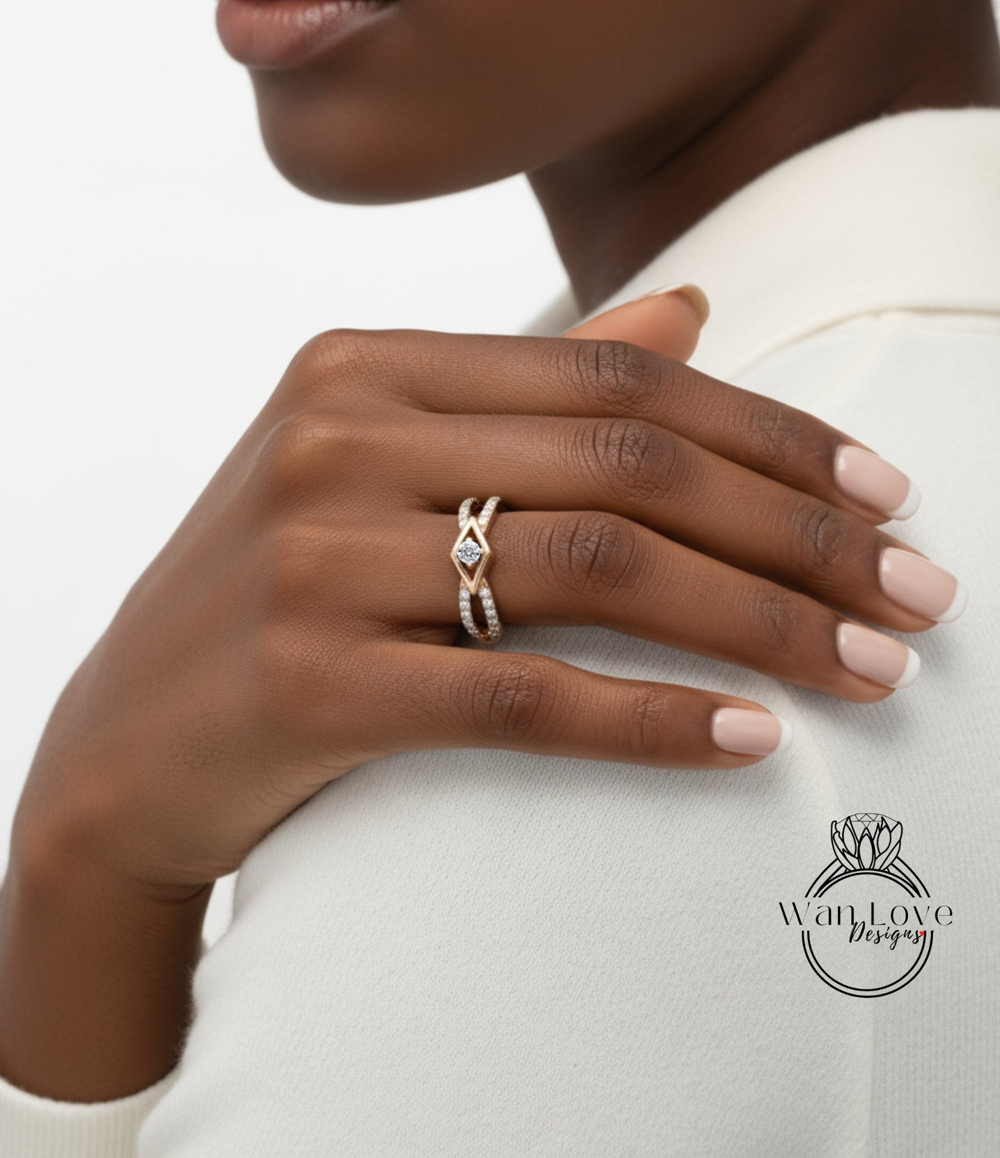 A close-up of a person's hand wearing a gold ring with a diamond, resting on a white sleeve.