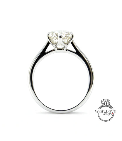 A close-up view of a silver engagement ring with a large, clear diamond set in the center.