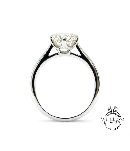A close-up view of a silver engagement ring with a large, clear diamond set in the center.