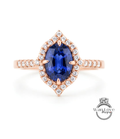 A rose gold ring with a large oval-shaped blue gemstone at the center, surrounded by smaller diamonds.
