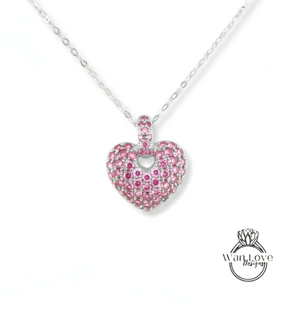 A heart-shaped pendant necklace with a large, sparkling pink gemstone in the center.