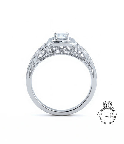 A silver engagement ring with a large central diamond and intricate metalwork detailing.
