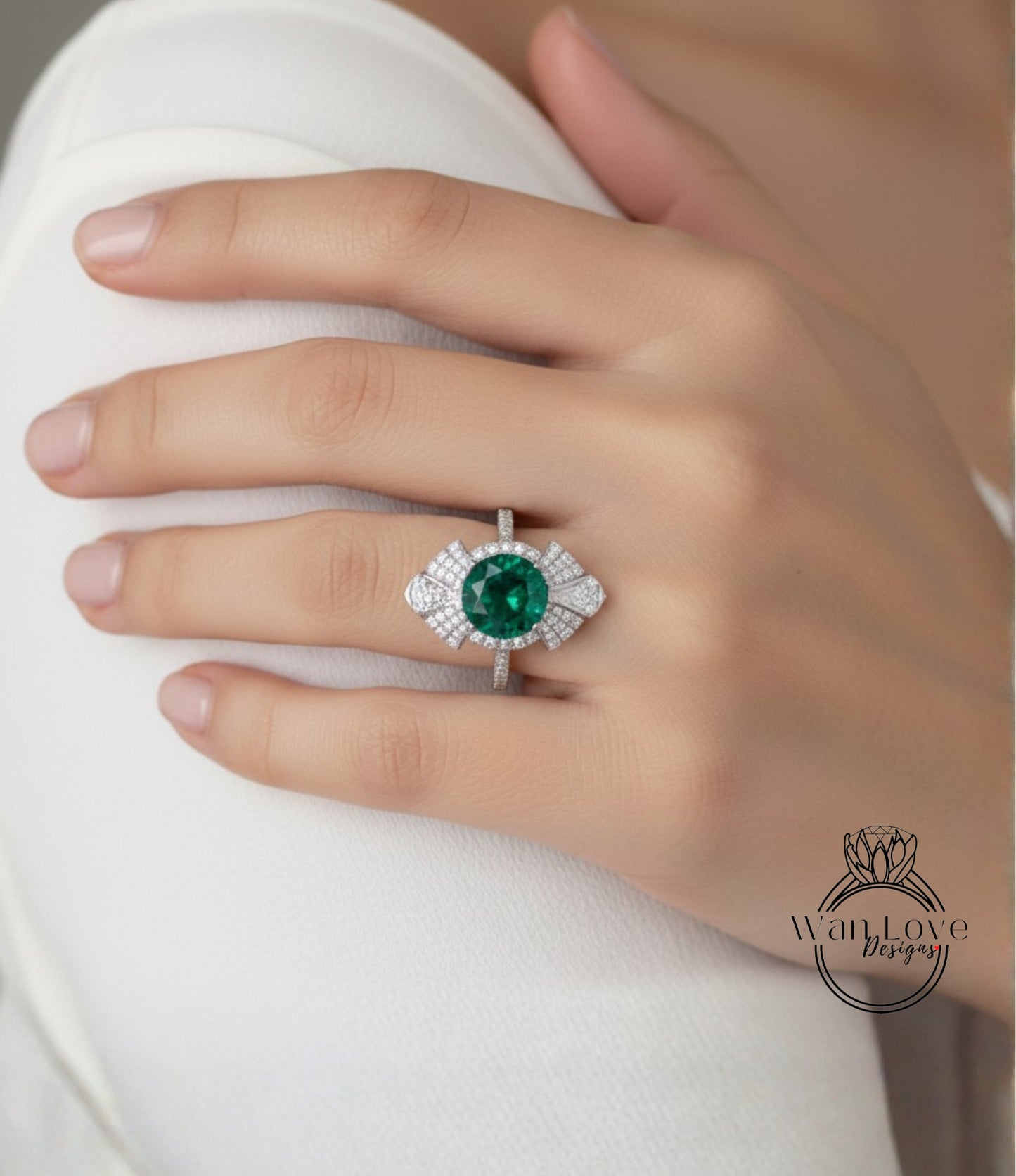 A close-up of a person's hand wearing a large, ornate ring with a large green gemstone.