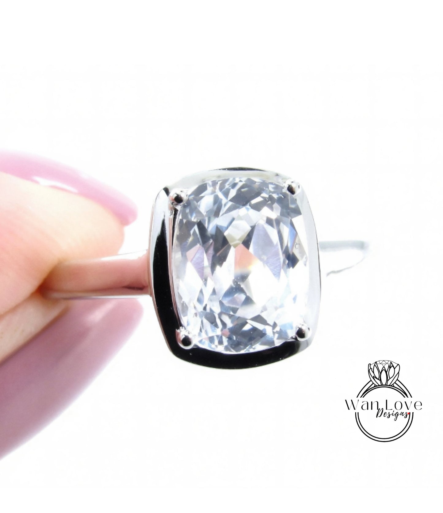 A close-up image of a person's hand holding a silver ring with a large, clear gemstone, likely a diamond.
