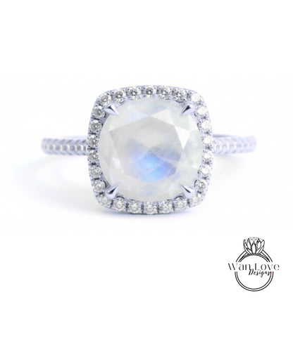 A diamond ring with a large oval-shaped gemstone, surrounded by a halo of smaller diamonds, set in a silver band.