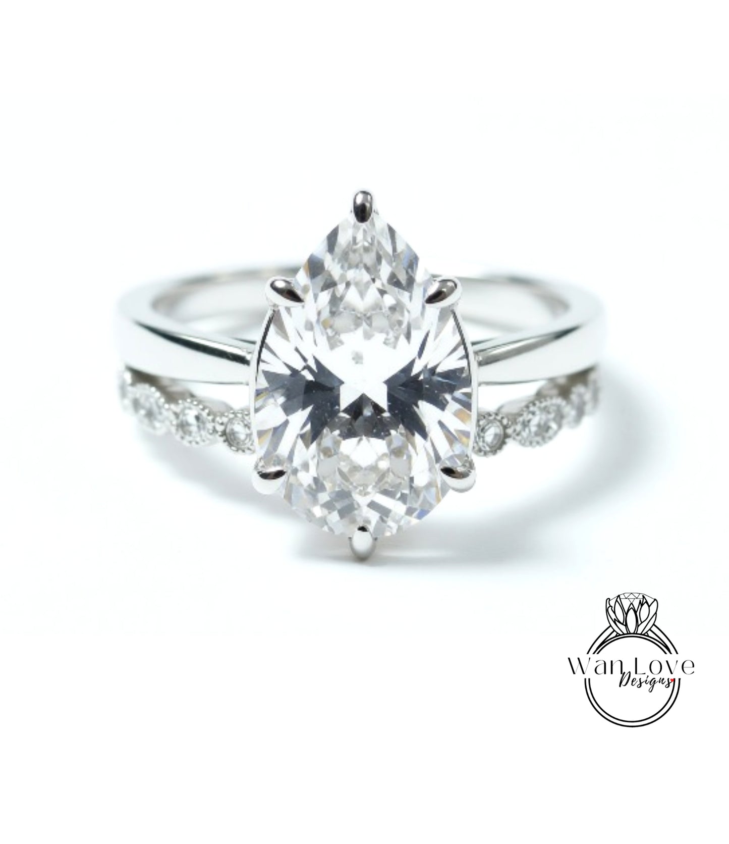 A close-up of a diamond engagement ring with a large pear-shaped diamond set in a silver band.
