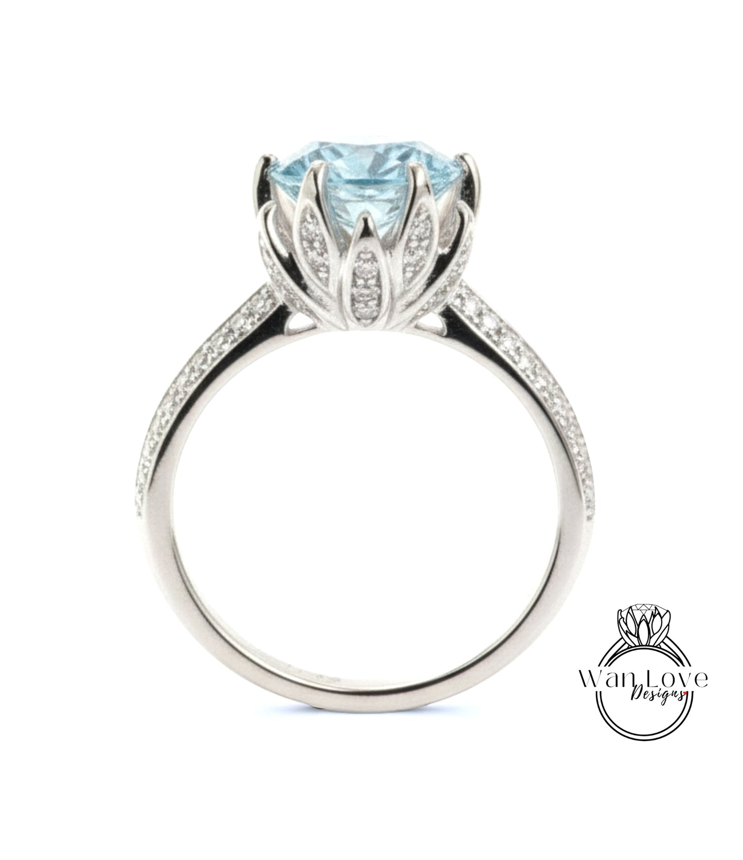A silver ring with a large blue gemstone, likely a diamond, set in a decorative flower-like design.