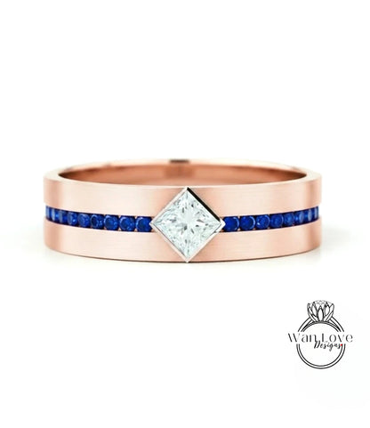 A rose gold ring with a large diamond set in the center, surrounded by blue gemstones.