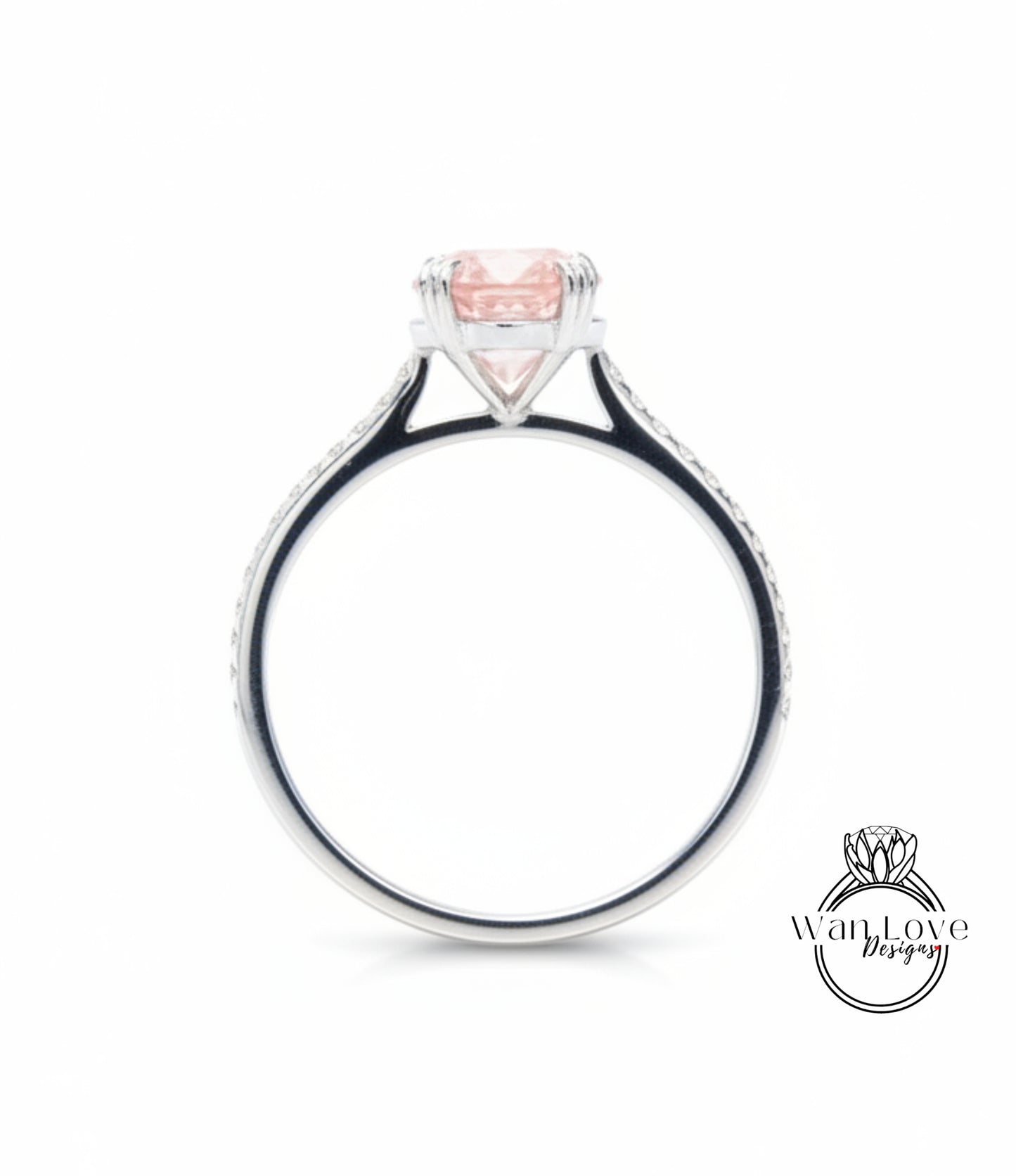 A silver ring with a large pink gemstone, possibly a diamond, set in the center.