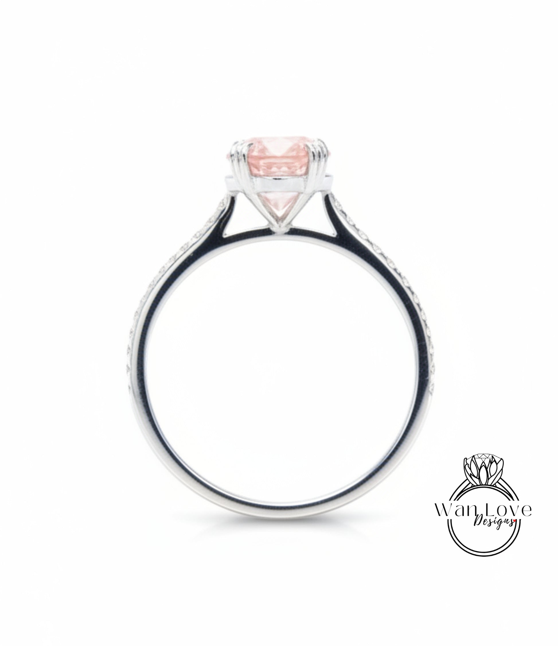 A silver ring with a large pink gemstone, possibly a diamond, set in the center.
