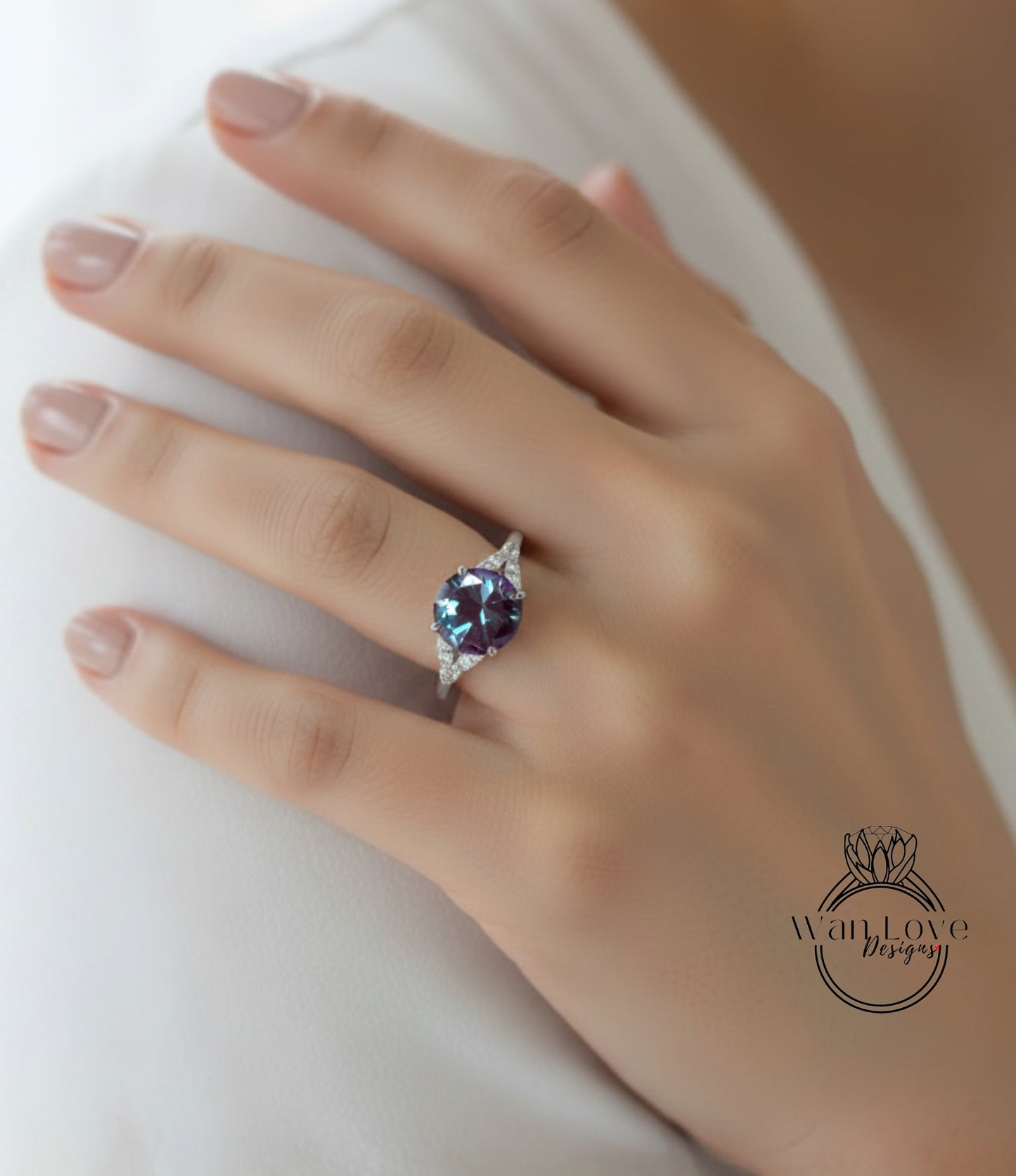A close-up of a hand wearing a ring with a large blue gemstone.