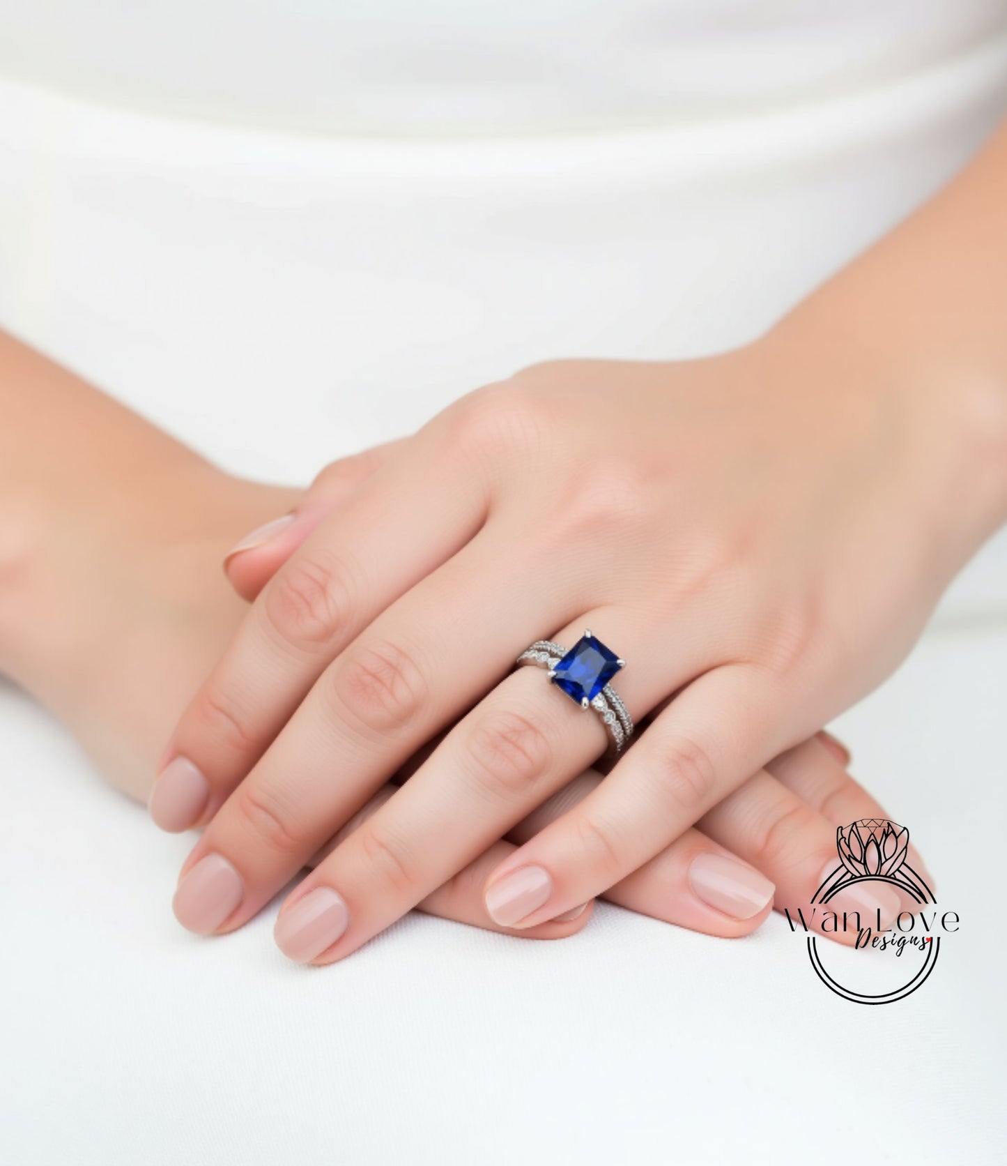 A close-up image of a person's hand wearing a ring with a large blue gemstone.