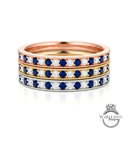 A stack of three rings with blue and white gemstones set in a gold band.