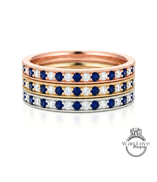 A stack of three rings with blue and white gemstones set in a gold band.