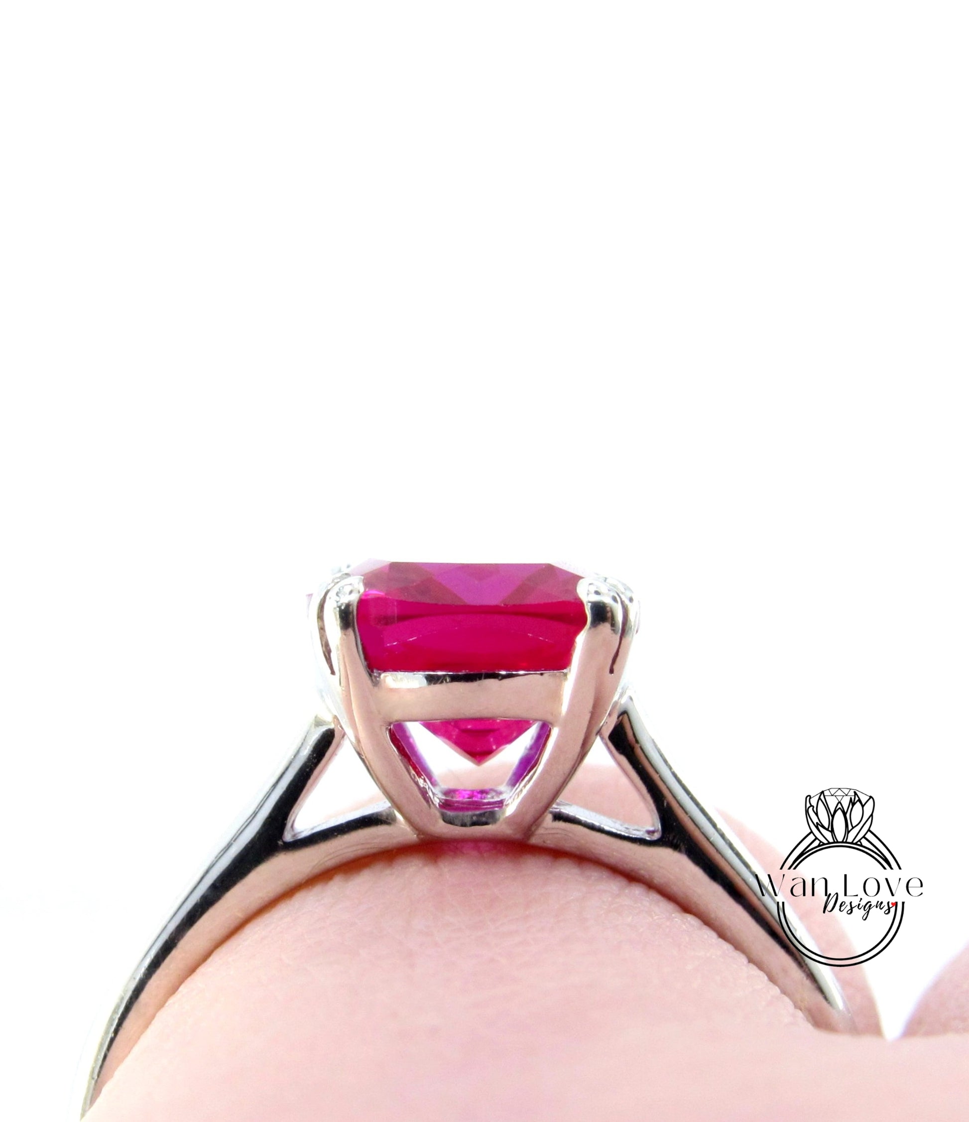 A close-up view of a silver ring with a large, vibrant pink gemstone set in the center.