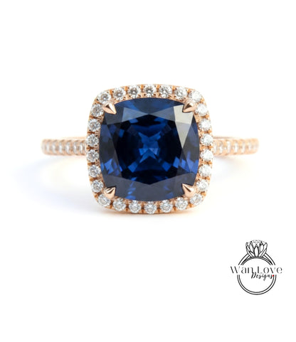A large blue gemstone set in a gold ring with a halo of smaller diamonds around the edge.