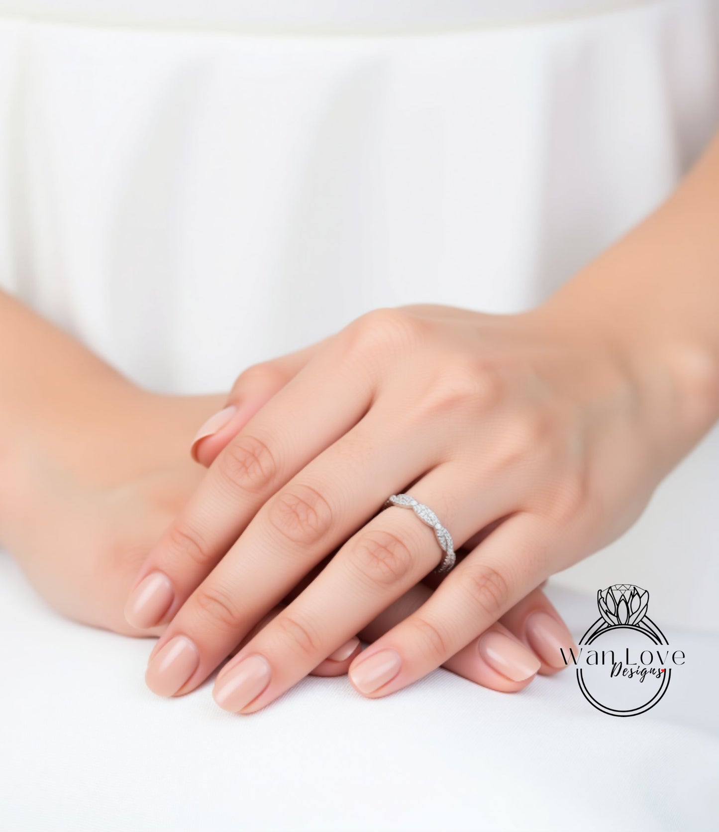 A close-up image of a person's hands wearing a diamond ring.
