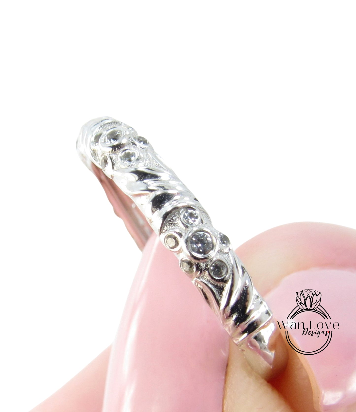 A close-up view of a silver ring with a decorative design, featuring small diamonds or gemstones.