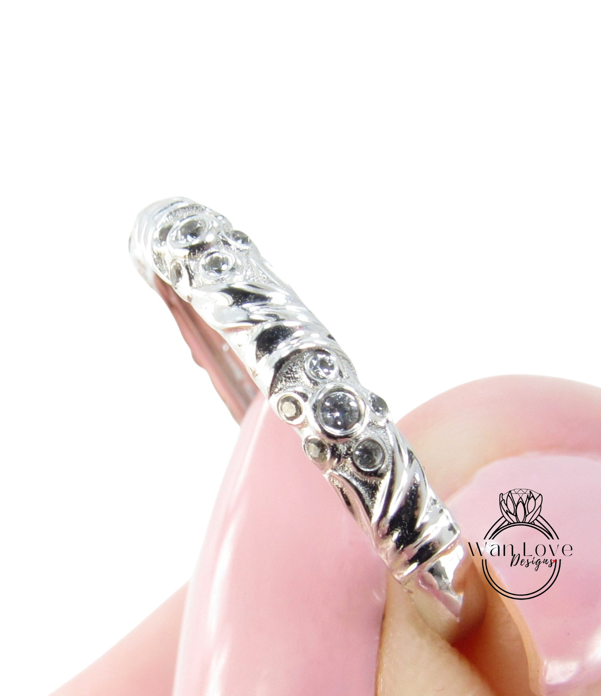 A close-up view of a silver ring with a decorative design, featuring small diamonds or gemstones.