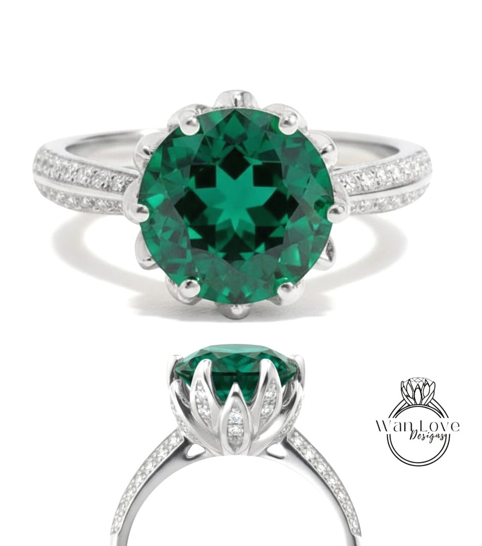 A stunning green gemstone ring with a large central stone surrounded by smaller stones, set in a silver band with a scalloped edge.