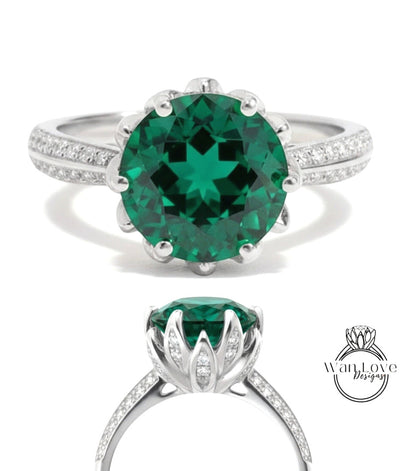 A stunning green gemstone ring with a large central stone surrounded by smaller stones, set in a silver band with a scalloped edge.