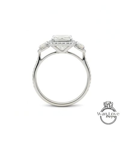A silver engagement ring with a large central diamond surrounded by smaller diamonds on either side.