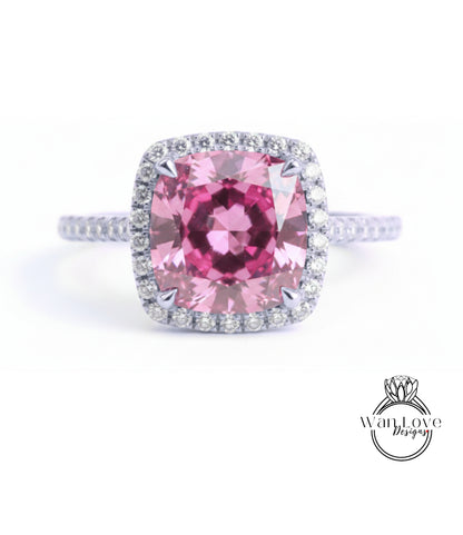 A large, pink gemstone ring with a halo of smaller diamonds around the center stone.