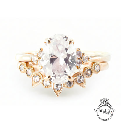 A gold ring with a large oval-shaped gemstone, surrounded by smaller diamonds and pearls.